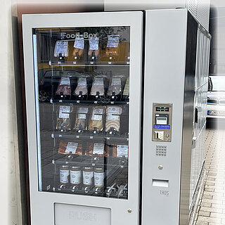 Wurstautomat der Metzgerei Schmid mit verpackten Wurstwaren, rund um die Uhr verfügbar, neben Geschäft platziert