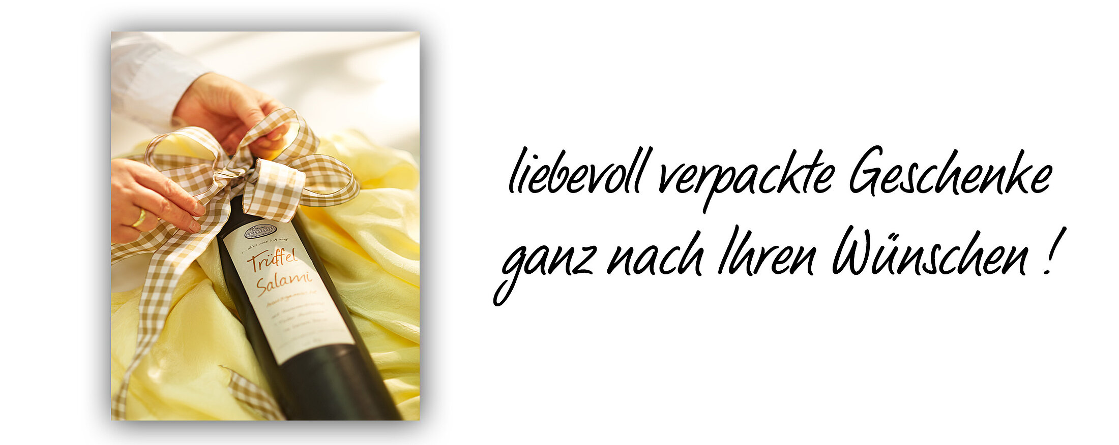 Geschenkverpackung mit Flasche "Trüffel Salami" dekorativ eingewickelt mit Schleife, daneben der Text: "liebevoll verpackte Geschenke ganz nach Ihren Wünschen!"
